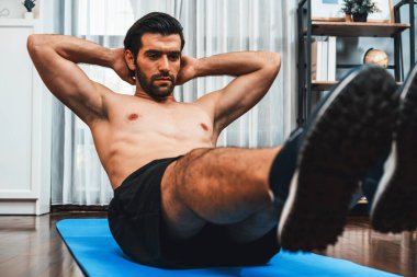 Atletik ve sporcu adam, evde vücut egzersizi yaparken spor ve spor yaşam tarzına uyum sağlamak için spor minderinde çatırdıyor. Gaiety ev egzersizi antrenman konsepti.