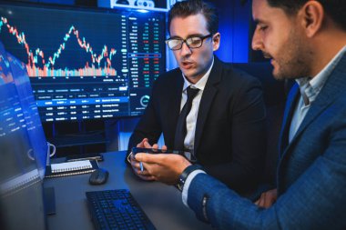 İki borsa simsarı gece monitörde döviz kurunda dinamik yatırım grafiğini tartışıyor. İş adamı ortakları iş yerindeki neon ışığı altında yüksek borsada kahve toplantısı yapıyor. Satılabilir.