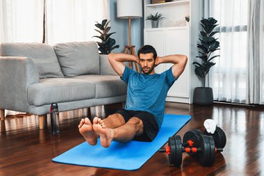 Atletik ve sporcu adam, evde vücut egzersizi yaparken spor ve spor yaşam tarzına uyum sağlamak için spor minderinde çatırdıyor. Gaiety ev egzersizi antrenman konsepti.