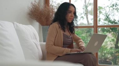 İnternette önemli bir iş için dizüstü bilgisayar kullanan Afro-Amerikalı bir kadın. Evde çalışan sekreter veya çevrimiçi içerik yazma.