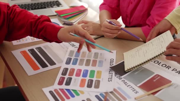 两名设计师在笔记本上起草新的设计布局 并与客户一起选择色彩 慢动作的手部特写负责项目的实施 在设计代理办公室进行彩色咨询 — 图库视频影像