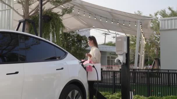 Fiatal Feltölteni Autó Akkumulátor Töltőállomás Parkolóban Bevásárló Táska Modern Megy — Stock videók