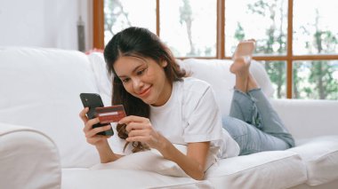 Kadın alışverişi ya da internet pazarında online ödeme modern yaşam tarzı için satılık eşyalar arıyor ve canlı siber güvenlik yazılımı tarafından korunan cüzdandan çevrimiçi ödeme için kredi kartı kullanıyor