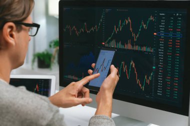 Akıllı borsa yatırımcıları ekranda akıllı telefon ile piyasa borsasını işaret ederek dizüstü bilgisayarın yanı sıra en yüksek dinamik yatırım oranını göstererek, modern işyerindeki veri planlamasına odaklanıyorlar. Bireysel.