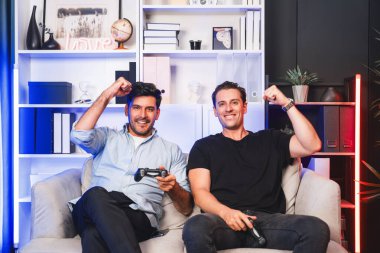 Kazanan ve kaybeden arkadaş oyuncular televizyonda video oyunu oynuyorlar. Stüdyo odasında neon mavi ışıklı joystickler kullanıyorlar. Memlekette rahat bir yaşam ve neşeli bir dövüş kazananı. Satılabilir.