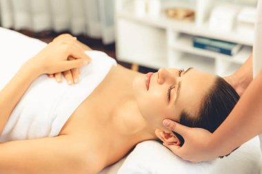 Kafkasyalı kadın stres önleyici kafa masajından ve lüks tatil beldesi ya da otel spa salonundaki modern ışık ortamında yüz güzelliği eğlencelerini şımartmaktan hoşlanıyor. Sessiz.