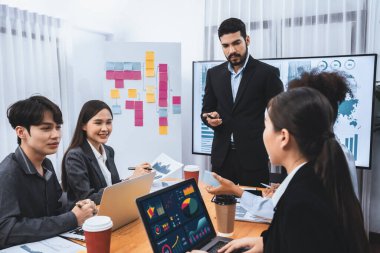 Pazarlama stratejisi için modern toplantıda veri analizi paneli ekranında sunan bir işadamı. Bir grup iş adamıyla konferans odasında iş sunumu. Uyum