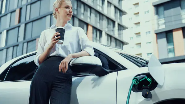 Businesswoman Drinking Coffee Recharge Her Electric Car Charging Station Residential — Stock Photo, Image