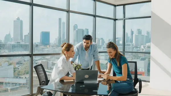 Group of skilled businesspeople sharing idea about marketing plan. Professional business team working together, discussing, talking at meeting table with laptop, document with cityscape. Tracery