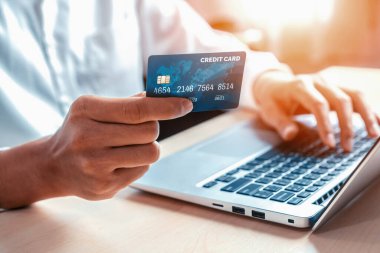 Genç adam, laptop bilgisayar başvurusu ya da web sitesinde online alışveriş yapmak için kredi kartı kullanıyor. E-ticaret ve online alışveriş konsepti. uds