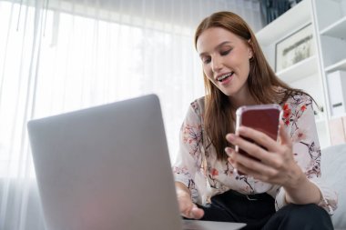 Genç mutlu kadın internetten alışveriş yaparak ürün satın alırken aynı zamanda internet üzerinden online ödeme sistemi ile çevrimiçi mağaza platformundan en yüksek siber güvenlik tarafından korunan ürünler sipariş ediyor.