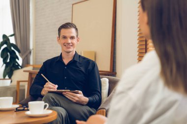 Psikolojik konsültasyon zihinsel problemde iyileşme kaydediyor. Psikiyatrist akıl hastalığı teşhisi koyarken mutlu genç bayan hasta terapi seansı yapıyor. Açılıyor