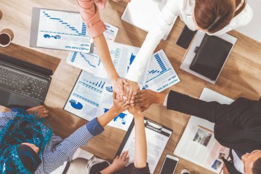 İş adamları ve iş kadınları, takım çalışması, destek ve iş birliğini gösteren çok kültürlü ofis odasındaki grup toplantılarında el ele tutuşuyorlar. Çeşitli işyerleri ve şirket çalışanları konsepti. uds