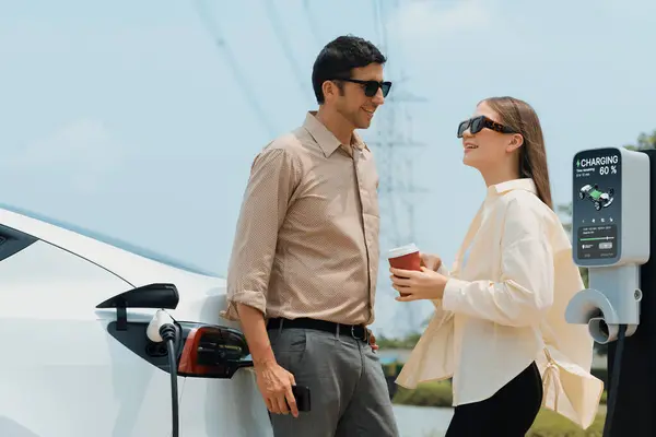 Jonge Echtpaar Met Koffie Opladen Auto Batterij Laadstation Aangesloten Elektrische — Stockfoto