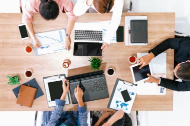 Modern ofisteki iş adamları ve iş kadınlarıyla grup toplantısındaki iş adamlarının en üst düzey görüşü, masada dizüstü bilgisayar, kahve ve belge ile. Kurumsal şirketler uds