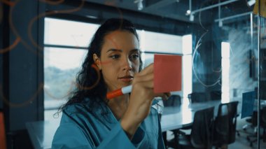 Genç İspanyol çalışanlar renkli yapışkan notlar yazıyorlar. Akıllı iş kadını pazarlama fikrini, beyin fırtınası stratejisini, iş planını paylaşıyor. Proje yöneticisi zihin haritası çiziyor. - Yakın çekim. Yönlendirici.