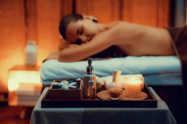 Aromaterapi masajı ambiyansı ya da spa salonu kompozisyon düzeneği bulanık kadınlara odaklı dekor mumları ve spa aksesuarları ile tatil köyü veya otel arka planında keyifli aroma spa masajı yapan. Sessiz.