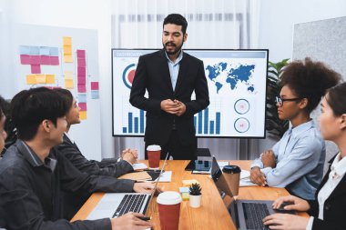 Pazarlama stratejisi için modern toplantıda veri analizi paneli ekranında sunan bir işadamı. Bir grup iş adamıyla konferans odasında iş sunumu. Uyum