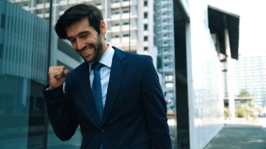 Cam duvarda yürürken neşeyle dans eden yetenekli bir iş adamı. Proje müdürü iyi haberler aldı, terfi aldı, başarılı bir iş buldu, aynı zamanda coşkuyu dile getirdi. Sevinçli..