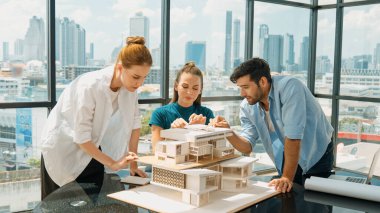 Akıllı mimar takımı ev tasarımı hakkında tartışırken yakışıklı erkek işçi dizüstü bilgisayar kullanarak fikir sunuyor. Profesyonel mühendis paylaşımı, beyin fırtınası tasarımı. İş tasarımı. İzleme