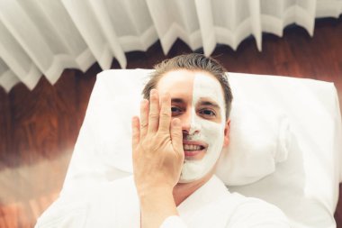 Kaplıca salonunun sakin atmosferi, insan müşterisi modern gün ışığında lüks yüz kremi masajıyla kendini yenileme zevkine kapılıyor. Yüz bakımı ve güzellik konsepti. Sessiz.