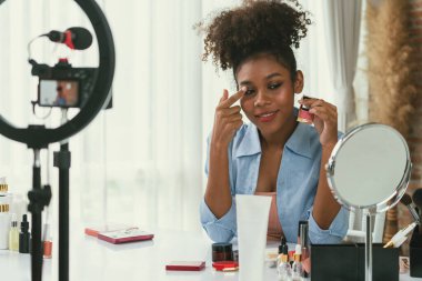 Kadın nüfuzlu kişi canlı yayında video görüntülerini çekiyor. Makyaj çok önemli sosyal medya ya da blog. Kozmetik stüdyosu ışıklandırmalı mutlu genç kız çevrimiçi pazarlama oturumu yayını için..