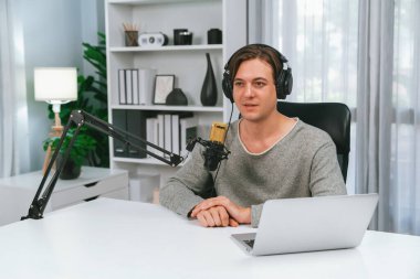 Sunucu kanalı, gülümseyen akıllı yayıncı kaydı, senaryosu ve akıllı telefonuyla sosyal medyada sohbet programı, kulaklık takarak modern ev stüdyosundaki video flamalarını kaydediyor. Bireysel.