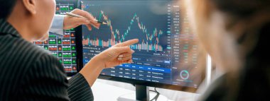 Yetenekli yatırımcılardan oluşan bir grup hisse senedi yatırımını tartışıyor. İşadamları yatırım kararları almadan önce hisse senedi çizelgelerine bakarlar. Borsa ticaret konsepti. Kesilmiş görüntü. - Yakın çekim. Filizlenen.