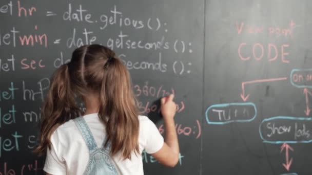 白种人女孩写黑板 转头看相机 而站在板上的工程提示或编码 编程系统写在Stem技术教室 Erudition — 图库视频影像