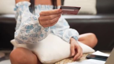 Genç bir kadın internet bankacılığı için kredi kartıyla dizüstü bilgisayar kullanıyor. Evinde online ödeme kapısı ile E ticareti yapıyor. Banka kartıyla modern ve kullanışlı online satın alma. Blithe