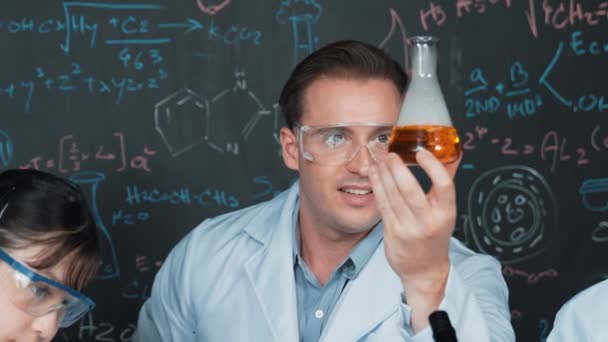 Smart Lärarlösning Bägare Medan Studenten Experimenterar Svarta Tavlan Med Kemisk — Stockvideo