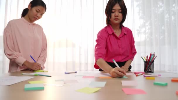 初创员工团队慢动作的手部特写头脑风暴战略营销计划 并在会议室的办公室桌上贴上彩色粘贴图 — 图库视频影像