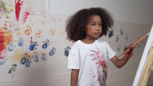 非洲女孩拿着画笔在美术课上画画布 漂亮的学习者一边看着画布 一边创作美丽的艺术品来发展想象力 创造性活动概念 Erudition — 图库视频影像