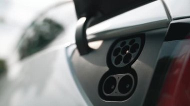 EV şarj prizi kapağı elektrikli arabaya bağlanıyor, EV araba aküsünü temiz çevre için sıfır CO2 emisyonu ile alternatif ve sürdürülebilir enerjiyle şarj ediyor. Titiz