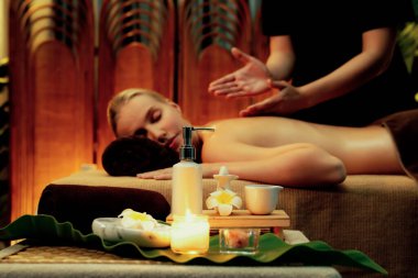 Aromaterapi masajı ambiyansı ya da spa salonu kompozisyon düzeneği bulanık kadınlara odaklı dekor mumları ve spa aksesuarları ile tatil köyü veya otel arka planında keyifli aroma spa masajı yapan. Sessiz.
