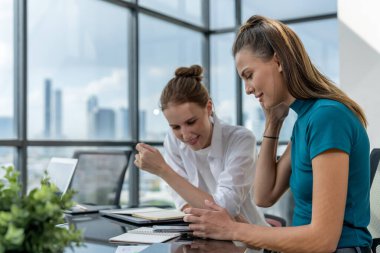 Beyin fırtınası pazarlama fikrini paylaşmak için buluşurken telefonu kullanan iki güzel beyaz iş kadınının portresi. Bir grup iş kadını birlikte çalışıyor. Şirket. İzleme.