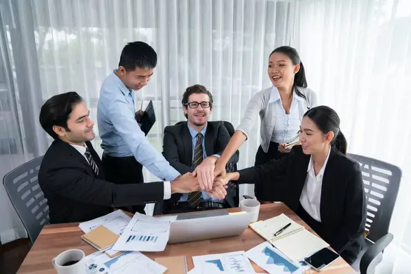 Group of happy businesspeople in celebratory gesture and successful efficient teamwork. Diverse race office worker celebrate after made progress on marketing planning in corporate office. Habiliment