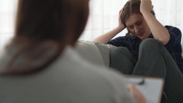 悲しいPtsdの女性は 心理学者 うつ病 または人生の失敗後の悲しみの精神的健康のための治療を受けています 診療所での感情についての主要な心理学者と話す疲労したトラウマの若い女性 — ストック動画