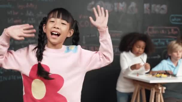 Menina Asiática Sorrir Acenar Para Câmera Enquanto Amigo Trabalhando Aprendendo — Vídeo de Stock