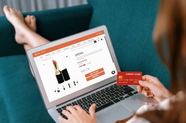 İnternet pazarından alışveriş yapan kadın modern yaşam tarzı için satış malzemeleri arıyor ve son derece siber güvenlik yazılımı tarafından korunan cüzdandan çevrimiçi ödeme için kredi kartı kullanıyor