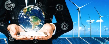 Alternatif enerji ile sürdürülebilirlik gelişimi kavramı. Çevre dostu rüzgar türbini çiftliği ve arka planda yeşil yenilenebilir enerji olan gezegenle insan eli ilgilenir. uds