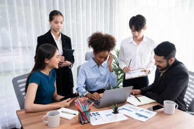 Çok ırklı analist ekibi toplantı masasındaki finansal verileri analiz etmek için BI Fintech yazılımı kullanıyor. Finansal konsol veri ekranında pazarlama göstergesi için analiz edilmiş grafikle birlikte. Uyum