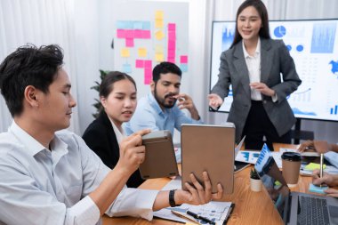 Genç Asyalı iş kadını modern toplantıda TV ekranında veri analizi paneli sunuyor. Bir grup iş adamıyla konferans odasında iş sunumu. Uyum