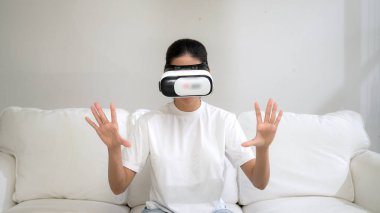 Canlı online alışveriş deneyimi için sanal gerçeklik gözlüğü kullanan genç bir kadın. Sanal gerçeklik VR yeniliği kadın dijital eğlence yaşam tarzı için optimize edildi.