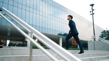 Profesyonel proje yöneticisinin iş yerine giderken elinde çantayla parkta ya da şehirde yürüyen yetenekli bir iş adamı. Büyümeyi temsil et, terfi al, yeteneğini arttır. Sevinçli..