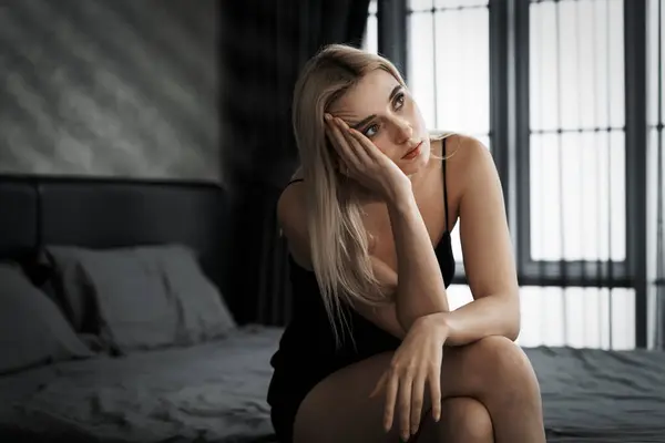 Young woman with critical depression and anxiety disorder from loneliness, mental sickness, or unwanted pregnancy, cuddling herself on dark bedroom. Overwhelming negative thought. Blithe