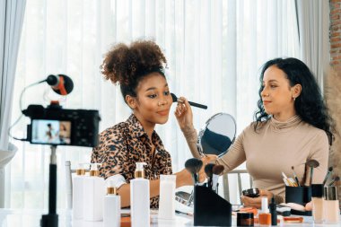 Kadın nüfuzlu kişi canlı yayında video görüntülerini çekiyor. Makyaj çok önemli sosyal medya ya da blog. Kozmetik stüdyosu ışıklandırmalı mutlu genç kız çevrimiçi pazarlama oturumu yayını için..