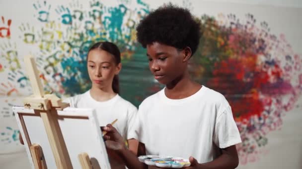 Разнообразные Счастливые Дети Рисуют Холст Вместе Красочной Окрашенной Стеной Умный — стоковое видео