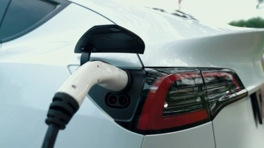 EV elektrikli araç EV şarj istasyonu ulusal park veya açık hava orman manzaralı. Çevre dostu EV arabalarla yaz ormanlarında doğal koruma. Yükselt