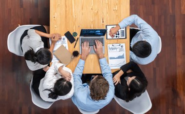 Panorama üst düzey iş analist grubu toplantı masasındaki finansal veri raporunu analiz ediyor. İş zekası analizine göre çizelge ve grafik paneli. Çok titiz.